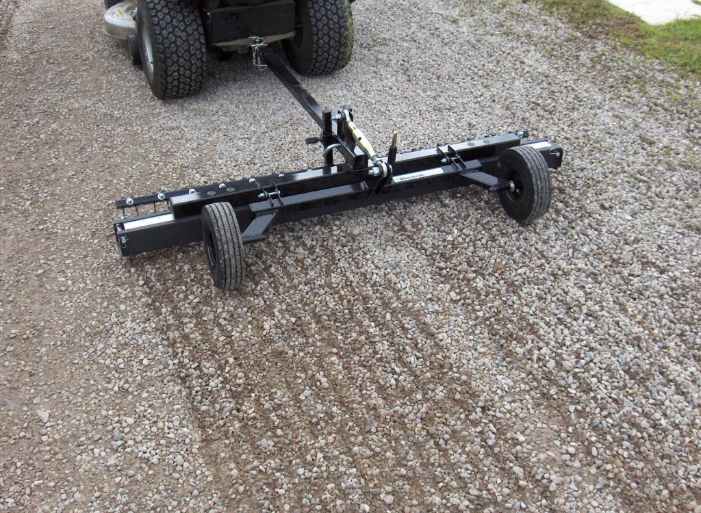 magnet-tow-behind-hog-series-showing-debris-digging-rake-on-driveway-bluestreak-equipment