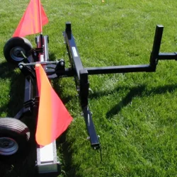 Balayeuse Rhino montrée avec le râteau à débris optionnel monté à l'avant de la balayeuse