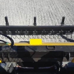 Vue de l'aimant Ocicat du râteau d'extraction des débris depuis la cabine du skidsteer