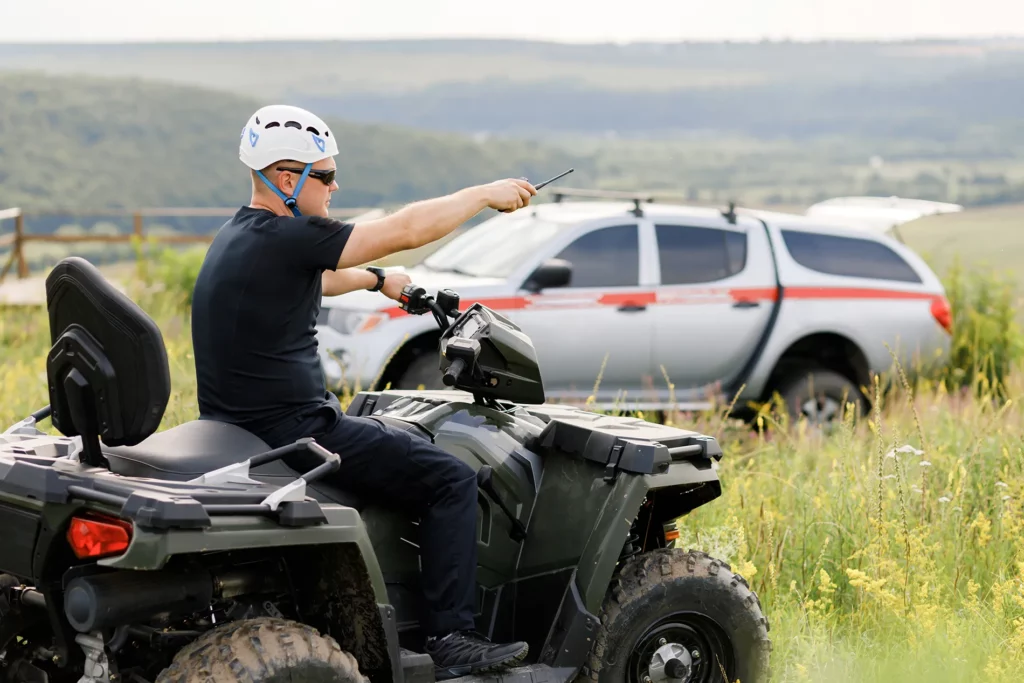 Search and Rescue Worker Riding ATV in Field
