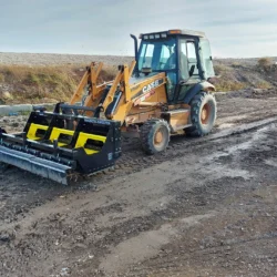 Retroexcavadora Case con imán montado en la parte frontal para la limpieza de instalaciones prefabricadas